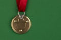 The medal is made from a tin can lid with a red award ribbon on a green background. Antimedal Royalty Free Stock Photo