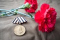 Medal For Victory over Germany in the Great Patriotic War of 1941-1945 and two red carnations Royalty Free Stock Photo