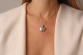 Medallion pendant in shape of heart made of silver on chain hangs around neck, on chest of a young girl. Love and romance, Royalty Free Stock Photo