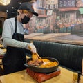Medan, Agustus 2021 - A Staff Of Korean All You Can Eat Restaurant Is Helping Customer By Cooking Their Meals
