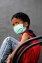 Medan, North Sumatra, Indonesia - February 2020: A small child wears a green mask for safety because of the current epidemic of th