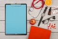 blank clipboard, pills, fruits, book, stethoscope, eyeglasses and watch on wooden background Royalty Free Stock Photo