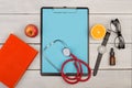 blank clipboard, pills, fruits, book, stethoscope, eyeglasses and watch on wooden background Royalty Free Stock Photo
