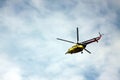 Medevac helicopter flying in blue cloudy sky. Image contains copy space