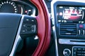 Media control buttons on the red steering wheel in black leather with computer monitor, modern car interior. Royalty Free Stock Photo