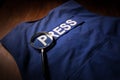 Media Journalism Global Daily News Content Concept. Blue journalist (press) vest in dark with backlight and fog. Royalty Free Stock Photo