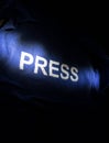 Media Journalism Global Daily News Content Concept. Blue journalist (press) vest in dark with backlight and fog. Media microphone Royalty Free Stock Photo