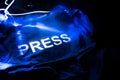 Media Journalism Global Daily News Content Concept. Blue journalist (press) vest in dark with backlight and fog. Media microphone Royalty Free Stock Photo