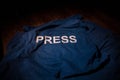 Media Journalism Global Daily News Content Concept. Blue journalist (press) vest in dark with backlight and fog. Royalty Free Stock Photo