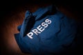 Media Journalism Global Daily News Content Concept. Blue journalist (press) vest in dark with backlight and fog. Royalty Free Stock Photo