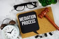 Mediation Process text on speech bubble with alarm clock and wooden gavel on marble background Royalty Free Stock Photo