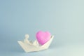 a man of white plasticine carries a heart in a paper boat Royalty Free Stock Photo