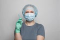 Medic doctor or nurse woman in professional uniform holding syringe on white background