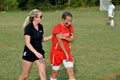 Medic helps a soccer player walk to sidelines after getting injured