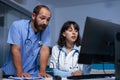 Medic and man assistant looking at computer display