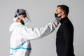 Medic man wearing face mask, getting temperature checked with digital thermometer of patient on white background. Medicine health