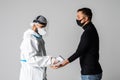 Medic man wearing face mask, getting temperature checked with digital thermometer of patient on white background. Medicine health