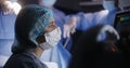 Medic sits in operating room and checks condition of patient