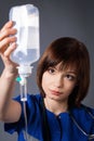 Medic uses a medical dropper. Girl on a gray background