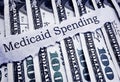 Medicaid Spending newspaper headline and cash