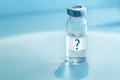 Medical ampoule on a blue background. Vaccination concept. Question mark on glass medical vial