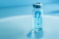 Medical ampoule on a blue background. Vaccination concept. Question mark on glass medical vial