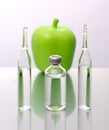 Medical ampoules and a bottle with an apple on a white background. Natural remedies Royalty Free Stock Photo