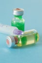 Medical ampoules with green and yellow liquid and a syringe