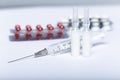 Medical ampoules, pills and syringe on white background.