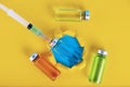 Medical ampoules and syringe on a yellow background. Copy space. Selective focus