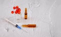 Medical ampules, syringe and red berry on textured background with copy space Royalty Free Stock Photo