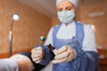 Medical assistant holds tweezers in his hands and drips an antibacterial solution onto cotton wool of brilliant green alcohol