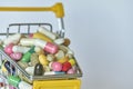 Medical background or concept. Close-up of a shopping trolley filled with colorful pills. Cart from the supermarket with different Royalty Free Stock Photo