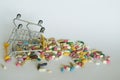 Medical background or concept. Close-up of a inverted shopping trolley filled with colorful pills. Cart from the supermarket with Royalty Free Stock Photo