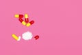 Medical background. Open red and yellow capsule pills on pink background Royalty Free Stock Photo