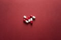 Medical background, red-white capsules on a red background. Top view of pills on red surface Royalty Free Stock Photo