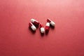 Medical background, red-white capsules on a red background. Top view of pills on red surface Royalty Free Stock Photo