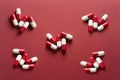 Medicines, pills. Medical background, red-white capsules on a red background. Top view of pills on red surface Royalty Free Stock Photo