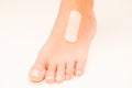 Medical band-aid is glued on top of woman foot, front view selective focus Royalty Free Stock Photo