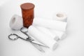 Medical bandage rolls, pills, sticking plaster and scissors on white background Royalty Free Stock Photo