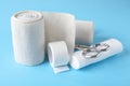 Medical bandage rolls, sticking plaster and scissors on light blue background Royalty Free Stock Photo