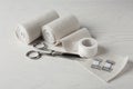 Medical bandage rolls, sticking plaster and scissors on white wooden table Royalty Free Stock Photo