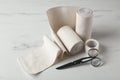 Medical bandage rolls, sticking plaster and scissors on white wooden table Royalty Free Stock Photo