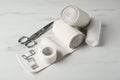 Medical bandage rolls, sticking plaster and scissors on white wooden table Royalty Free Stock Photo