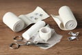 Medical bandage rolls, sticking plaster and scissors on wooden background Royalty Free Stock Photo