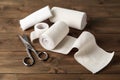 Medical bandage rolls, sticking plaster and scissors on wooden table Royalty Free Stock Photo