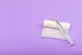 Medical bandage and syringe on a lilac background. A gauze roll on which the syringe lies. Dressing for medical purposes. Space