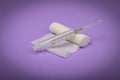 Medical bandage and syringe on a lilac background. A gauze roll on which the syringe lies. Dressing for medical purposes.