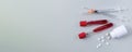 Medical banner with blood samples test tube, syringes and white tablets on light gray background top view Royalty Free Stock Photo