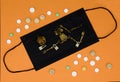 Medical black mask, human skeleton, pills on an orange background. Concept of Halloween, addiction, drug addiction, bad habits.